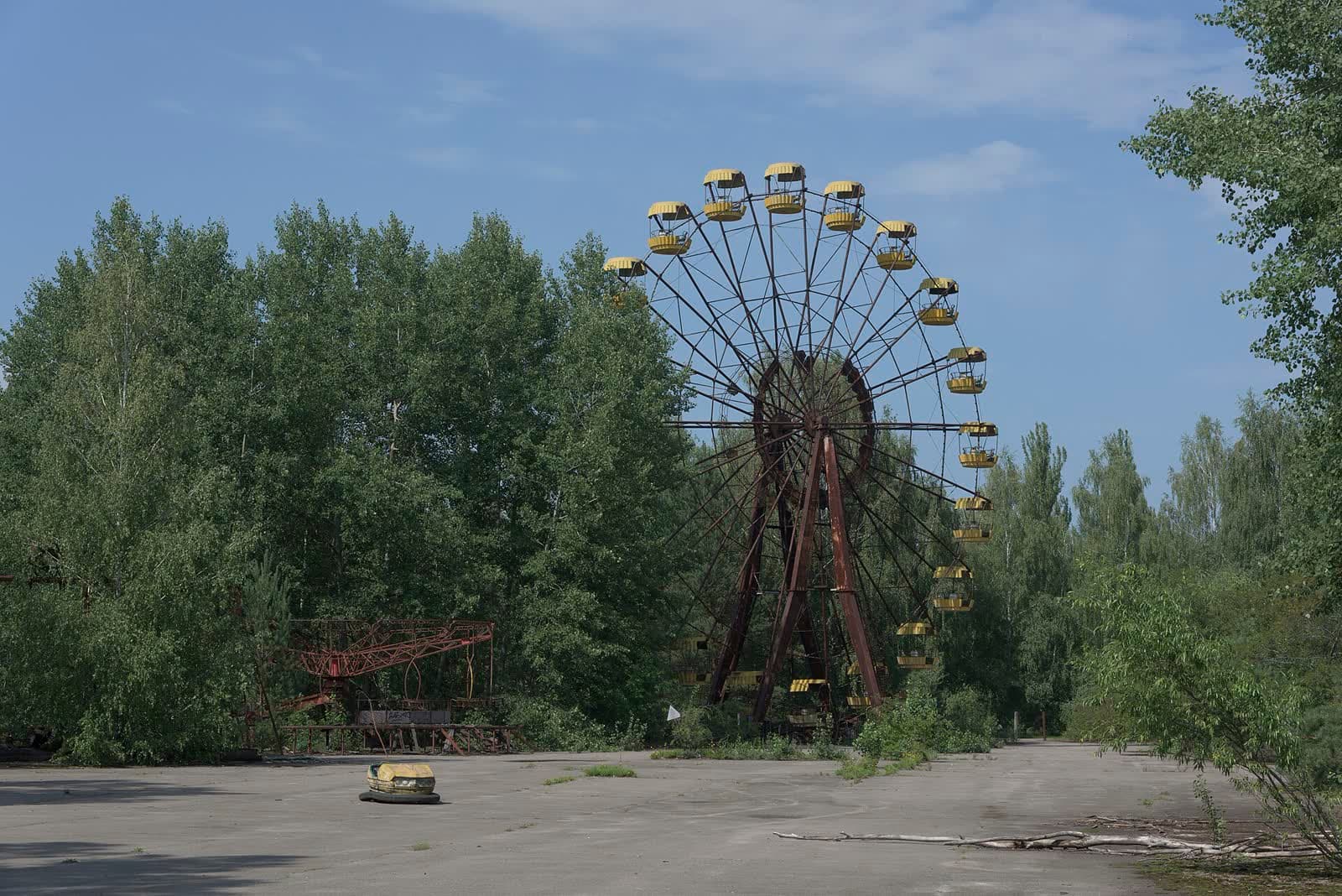 The abandoned yellow ferris wheel of Pripyat surrounded by overgrown trees